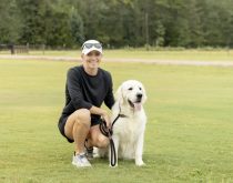 a person holding a dog in a field
